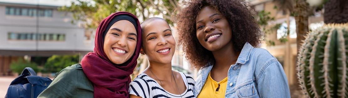 Two international students stand smiling in a Pima Common Area